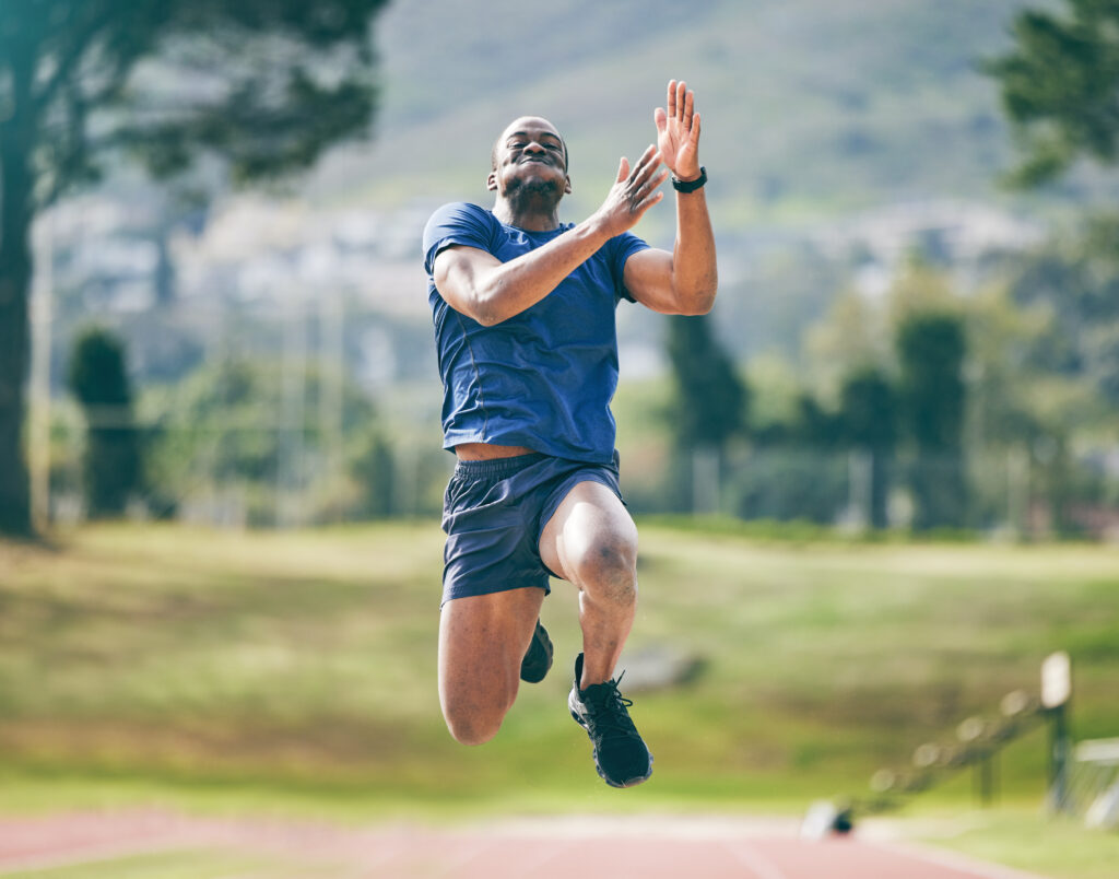 black-man-high-jump-fitness-exercise-stadium-training-workout-practice-sports-wellness-male-athlete-exercising-jumping-performance-endurance-competition-outdoors