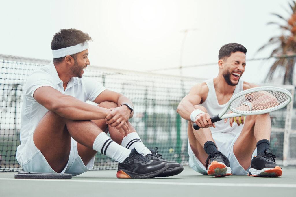 friends-tennis-break-with-racket-laughing-happy-match-with-equipment-court-fitness-sports-outdoor-team-game-people-men-joke-performance-field-funny