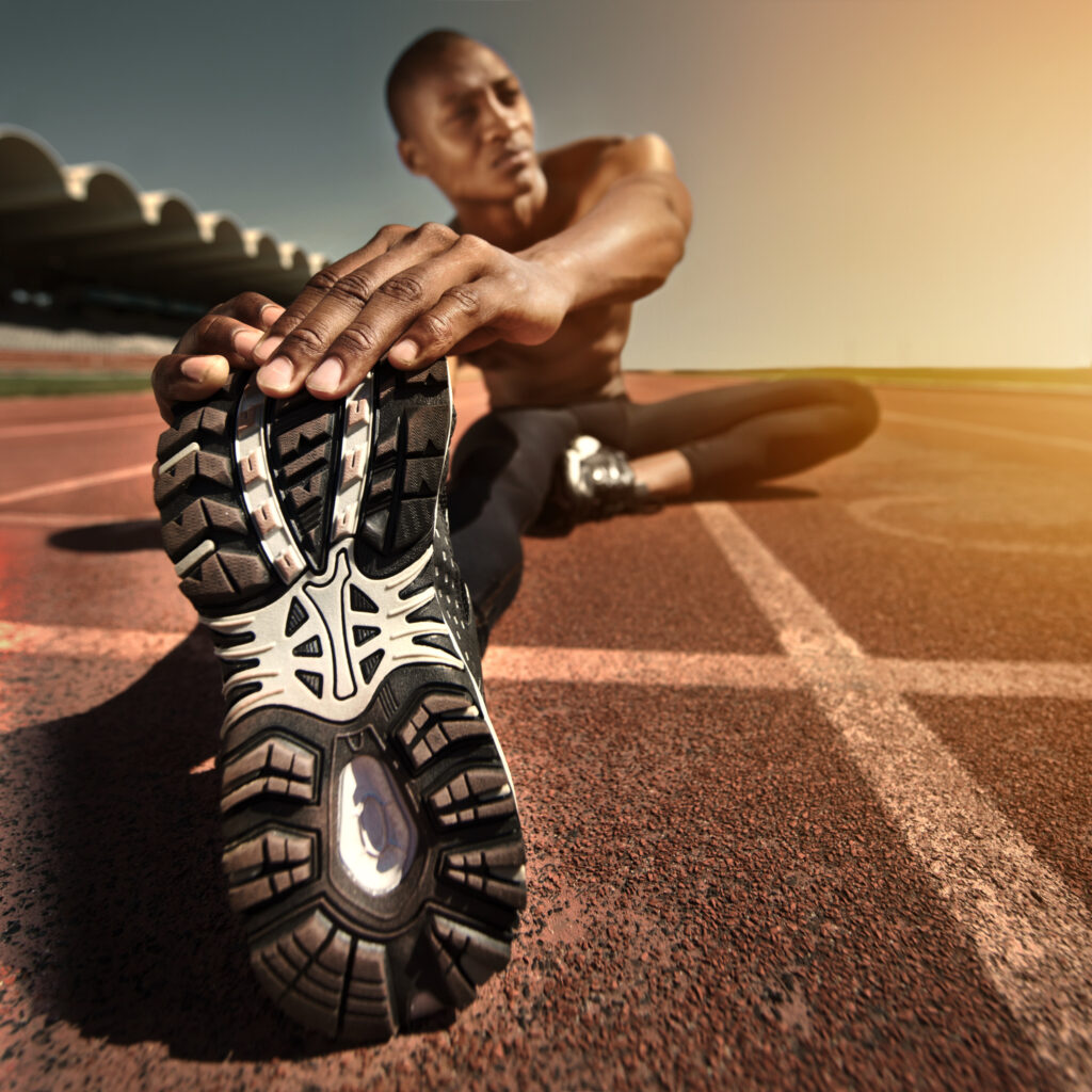 man-face-stretching-leg-ground-outdoors-fitness-health-sports-performance-black-male-person-athlete-warmup-track-workout-commitment-ready-train-cardio